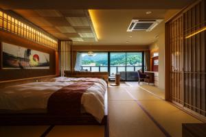 山之内町阿布拉雅拓森酒店的一间卧室设有一张大床和一个大窗户