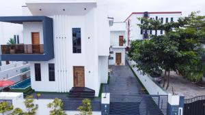 莱基SID LUXURY SHORTLET LEKKI - Lagos with Swimming Pool, PS 5, Snooker & Table Tennis的白色的房子,有楼梯通往