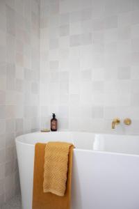爱丽丝湾Sunnymead Hotel的白色浴缸,上面有棕色毛巾
