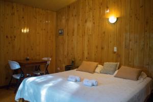 蒙泰韦尔德哥斯达黎加Cabañas Lys的一间卧室配有一张床,上面有两条毛巾