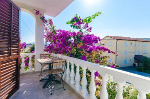 洛帕Apartments Ljubica J的白色围栏上种有紫色花卉的阳台