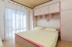 洛帕Apartments Ljubica J的卧室配有粉色和白色的床和窗户。