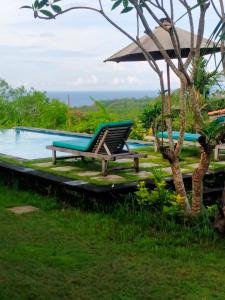 乌鲁瓦图绿碗海滩别墅的靠游泳池边的椅子,背景是大海