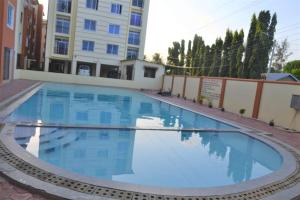 蒙巴萨Mtwapa HomeStay 3br Apartments的大楼前的大型蓝色游泳池