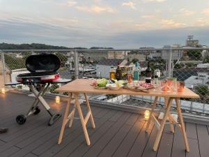 镰仓市plat hostel keikyu kamakura wave的阳台配有2张带食物和烧烤的桌子。