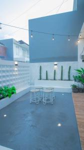 巴图Villa Shiny with Karaoke & Chill Spot的大楼内带2张桌子和椅子的庭院