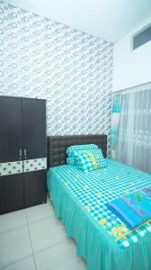巴图Villa Shiny with Karaoke & Chill Spot的一间卧室配有一张带蓝色棉被的床