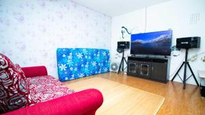 巴图Villa Shiny with Karaoke & Chill Spot的客厅配有红色沙发和平面电视