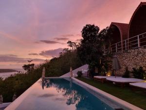蓝梦岛Butterfly Villas Nusa Ceningan的日落时分享有海洋美景的游泳池