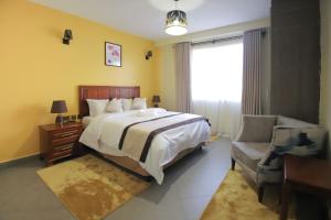 内罗毕Lantern Serviced Apartments的卧室配有床、椅子和窗户。