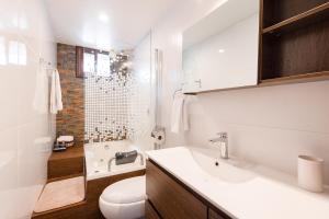 乌鲁班巴Town Center Apartments的浴室配有盥洗盆、卫生间和浴缸。