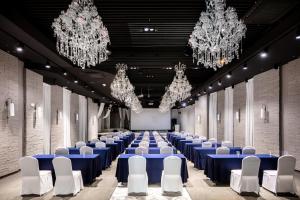 首尔Hotel Bernoui Seoul的大厅设有蓝色桌子、白色椅子和吊灯