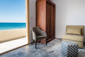 埃皮斯科皮·罗希姆诺Musela Studios的客房设有椅子和海景窗户。