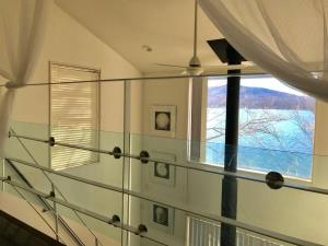 山中湖村Away From Noise,View Fuji Mt In The Designer House的一间设有玻璃楼梯的房间,设有窗户