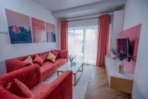努沃勒埃利耶The Breeze Luxury Apartment的客厅配有红色的沙发和桌子