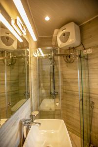 努沃勒埃利耶The Breeze Luxury Apartment的一间带玻璃淋浴和水槽的浴室