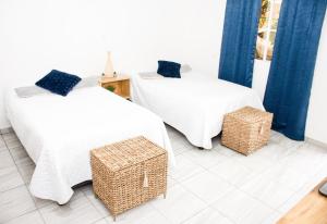 Habitación Agua - Villa Valle Campo的一间设有两张床和两个柳条篮的房间