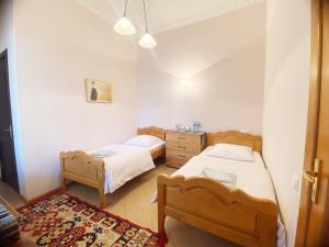 姆茨赫塔Hotel Magdalena的卧室配有两张床、梳妆台和地毯。