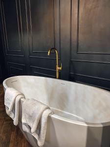 切尔诺夫策Central Gate apartment的浴室内提供白色浴缸和2条毛巾