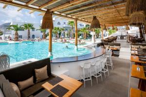 卡马利Smy Mediterranean White Santorini的一个带桌椅的游泳池的度假酒店