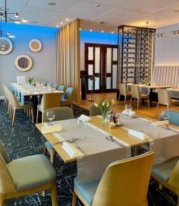 普鲁什库夫阿卡斯酒店的用餐室配有长桌子和椅子