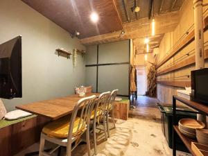 滨松365BASE户外旅馆的一间带木桌和椅子的用餐室