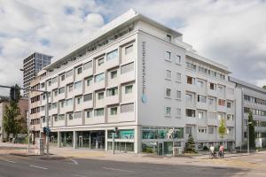 巴塞尔VISIONAPARTMENTS Basel Nauenstrasse - contactless check-in的街道拐角处的白色大建筑