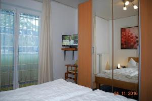黑灵斯多夫Strandoase-Whg-16的一间卧室设有一张床、一台电视和一个窗口。