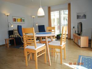黑灵斯多夫Strandoase-App-04的客厅配有餐桌和椅子