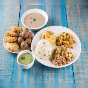 DongargarhIndian Family Lodge, Rajnandgaon, Chhattisgarh的一张桌子,上面有三盘食物和两碗汤