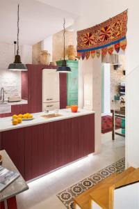 塞维利亚CSE San Bernardo的厨房配有红色橱柜和白色台面
