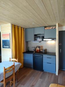 布齐耶比利牛斯2000Appartement confort et style en pied de piste的一间厨房,内设蓝色橱柜和一张桌子