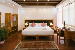 帕坦塔加发住宿加早餐旅馆的一间卧室配有一张床、一张桌子和一张四柱床。