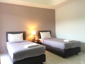 卡马拉海滩Kamalaburi Guesthouse的酒店客房,设有两张床和一盏灯