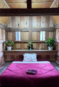 兰特包Toraja Homestay & Coffee Bunna的一间卧室配有粉红色的床和两个遥控器