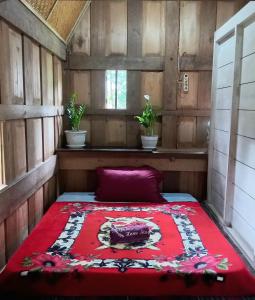 兰特包Toraja Homestay & Coffee Bunna的一张床上的床上,上面有红毯