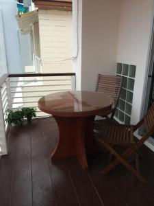 卡塔海滩Glitter House Phuket的阳台配有一张木桌和一把椅子
