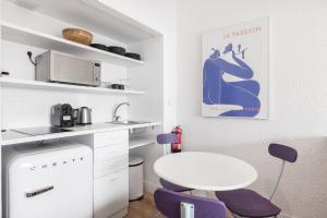 卡斯卡伊斯Equador Superior Suites by Olala Homes的厨房配有白色桌子和紫色椅子