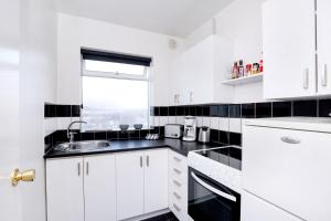 雷克雅未克City view, bright & cozy - Free parking (A4)的白色的厨房设有水槽和窗户