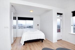 雷克雅未克City view, bright & cozy - Free parking (A4)的白色卧室设有床和大窗户