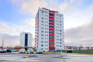 雷克雅未克City view, bright & cozy - Free parking (A4)的停车场内红色点缀的高高的白色建筑