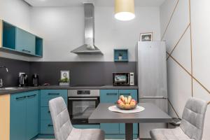 弗尔沙茨La Casa 2的厨房配有蓝色橱柜和一碗水果放在桌子上