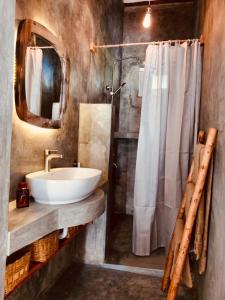 布韦朱Helwas Zanzibar Beach Hotel的一间带水槽、镜子和淋浴的浴室