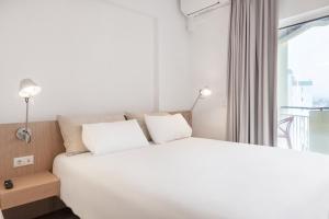 卡斯卡伊斯Equador Superior Suites by Olala Homes的窗户客房内的一张白色床