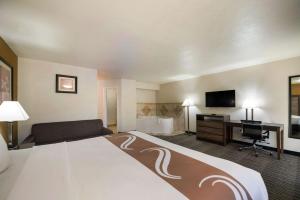 拉夫金Quality Inn & Suites Lufkin的酒店客房设有一张大床和一张书桌。