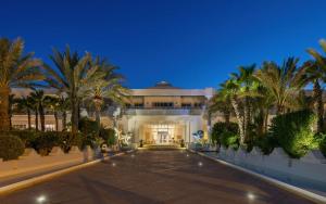 乌姆苏克杰尔巴皇宫丽笙度假酒店及海水浴的一座棕榈树环绕的大建筑