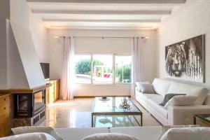 圣埃乌拉利亚Gorgeous Villa near Ibiza centre的客厅配有白色沙发和窗户