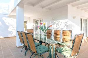 圣埃乌拉利亚Gorgeous Villa near Ibiza centre的一张带椅子的玻璃桌和花瓶