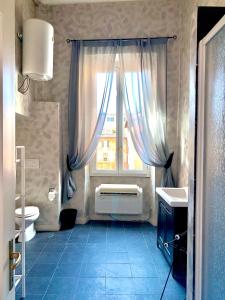 罗马维科罗多利亚公寓的浴室设有窗户、卫生间和水槽。