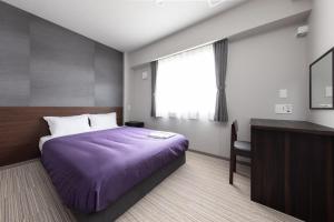 千岁Hotel Classe Stay Chitose的一间卧室配有一张床、一张书桌和一个窗户。